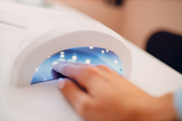 istock Female hand inside drying UV light machine in nail salon 1851410396