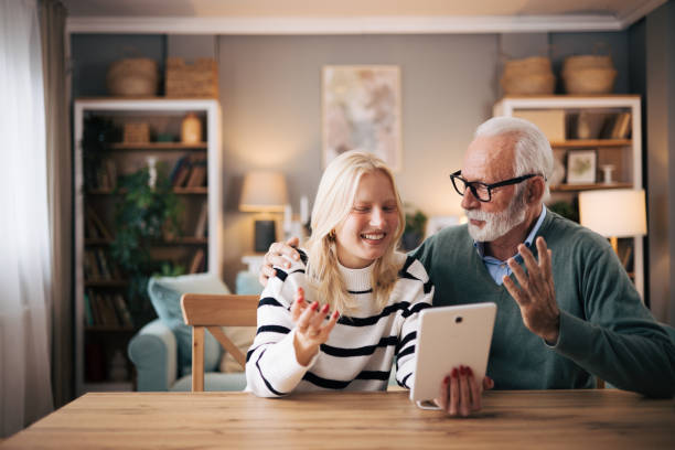 istock Granddaughter and grandfather using tablet computer to video call loved ones 1851439619