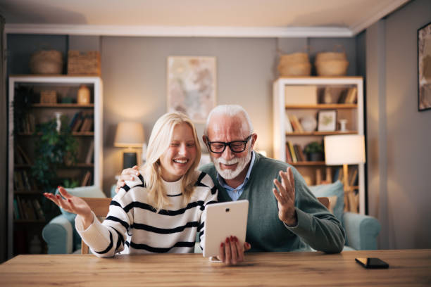 istock Granddaughter and grandfather using tablet computer to video call loved ones 1851441468
