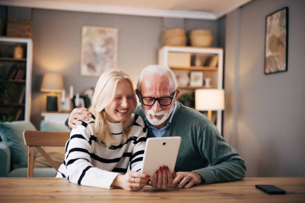 istock Granddaughter and grandfather using tablet computer to video call loved ones 1851442543