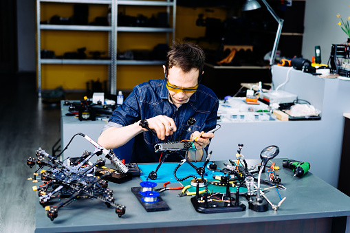 Engineer working on racing fpv drone in workshop