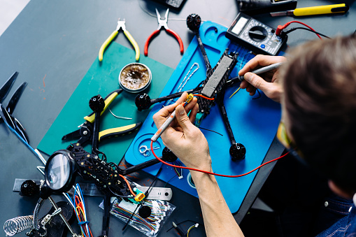 Engineer working on racing fpv drone in workshop