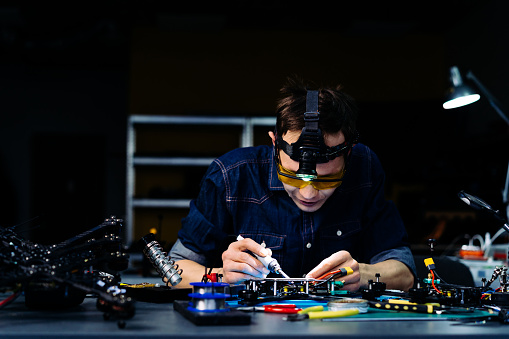 Engineer working on racing fpv drone in workshop