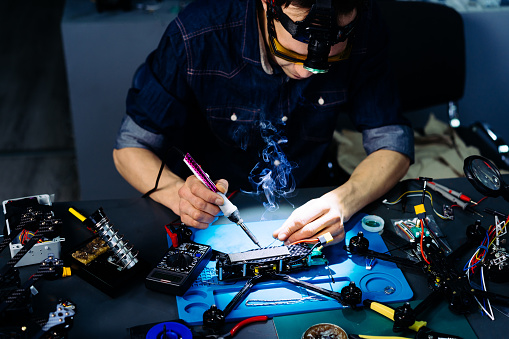 Engineer working on racing fpv drone in workshop