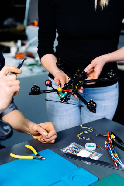 istock Man and woman engineers working on racing fpv drone in workshop 1851444754