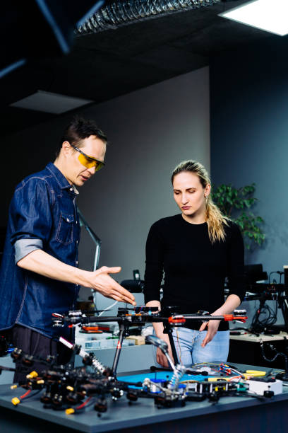 istock Man and woman engineers working on racing fpv drone in workshop 1851444766