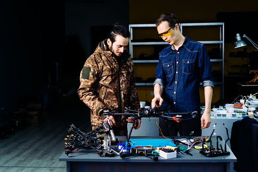 Engineer presenting new technology fpv combat drone to military soldier.