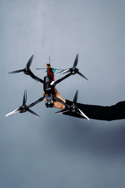istock Hand holding fpv racing drone on blue background. Starting motors 1851445480
