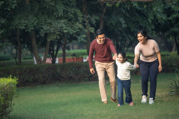 istock Playful girl pulling parents in garden 1851463937