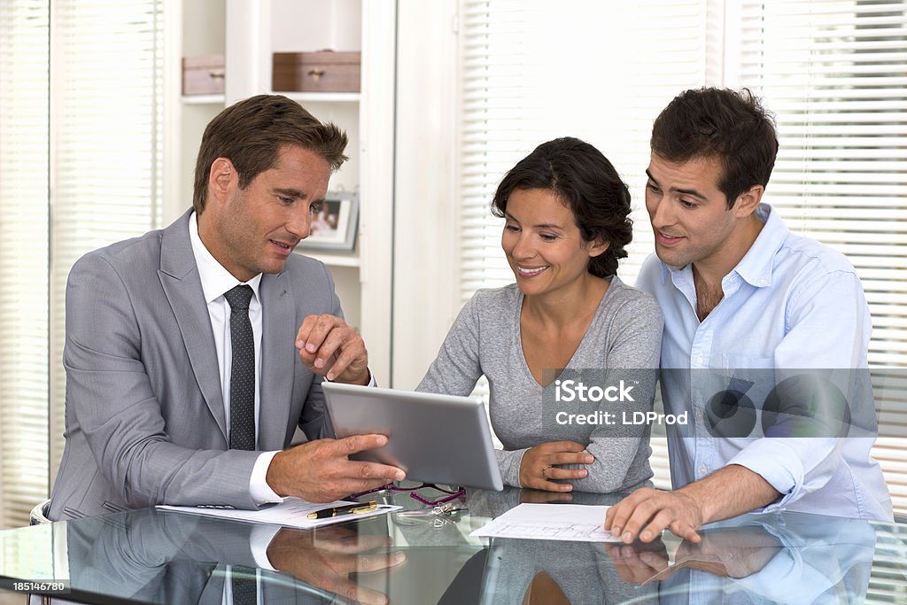 Architecte presenting a new project, smiling young couple woman man businessman banker tablet pc indoor contract Customer Stock Photo