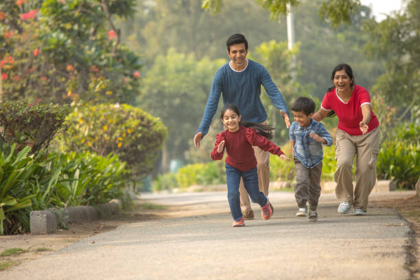 rodzice biegnący za dziećmi w parku - offspring family love india zdjęcia i obrazy z banku zdjęć