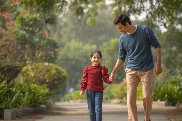 istock Father and daughter walking in garden 1851470139