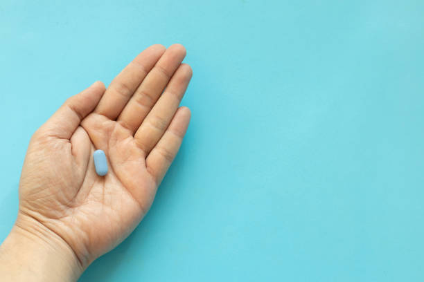 istock close up top view man hand with Prep pills on blue background with space for world aids day and hiv prevention concept 1851470672