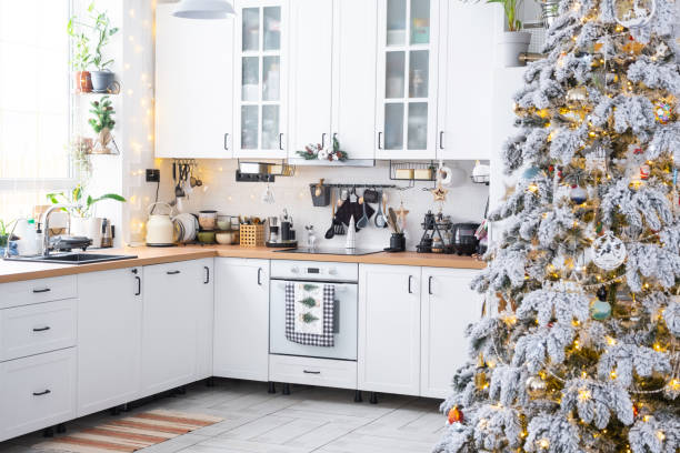 istock Festive Christmas decor in white kitchen, modern rustic interior with a snowy Christmas tree and fairy lights. New Year, Christmas mood, cozy home. The general plan 1851478399