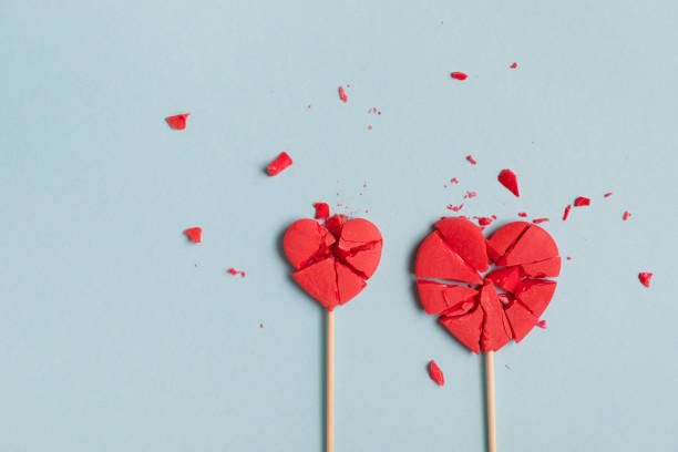 istock Valentine day concept with two broken red lollipop hearts on pastel blue background top view. Flat lay style. Relationship difficulties, unrequited love and break up. 1851479975