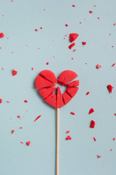 istock Valentine day concept with broken red lollipop hearts on pastel blue background top view. Flat lay style. Relationship difficulties, unrequited love and break up. 1851480499
