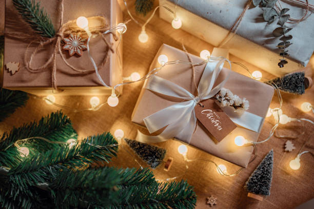 istock Handmade gift box with note card Merry Christmas and Christmas tree branch decor on table background, Christmas and new year. 1851482062