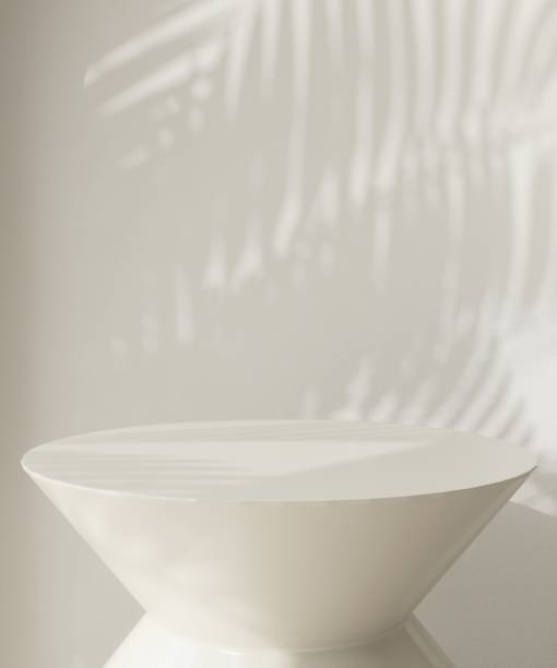 istock Round cream podium table in sunlight, palm tree leaf shadow on wall arch 1851568579