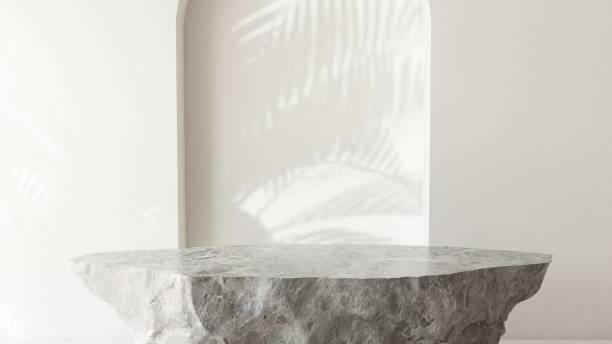 istock Gray rock stone podium table in sunlight, palm tree leaf shadow on wall 1851569328