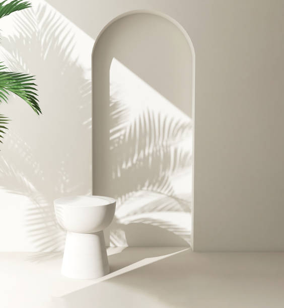 istock Cream white round podium table in sunlight, palm tree leaf shadow on wall arch 1851569499