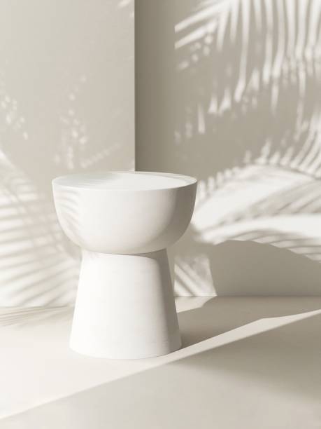 istock Cream white round podium table in sunlight, palm tree leaf shadow on wall 1851569502