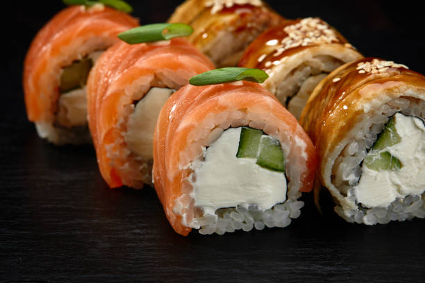 istock Traditional Japanese rolls with salmon and smoked eel in set on black background. 1851571097