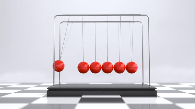 Red Newton's cradle is on a wooden stand