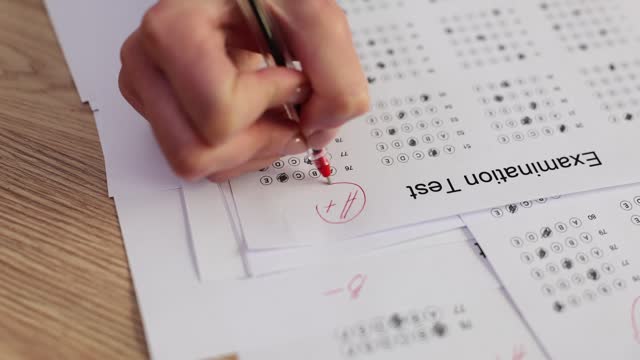 Teacher evaluates examination test and student answers