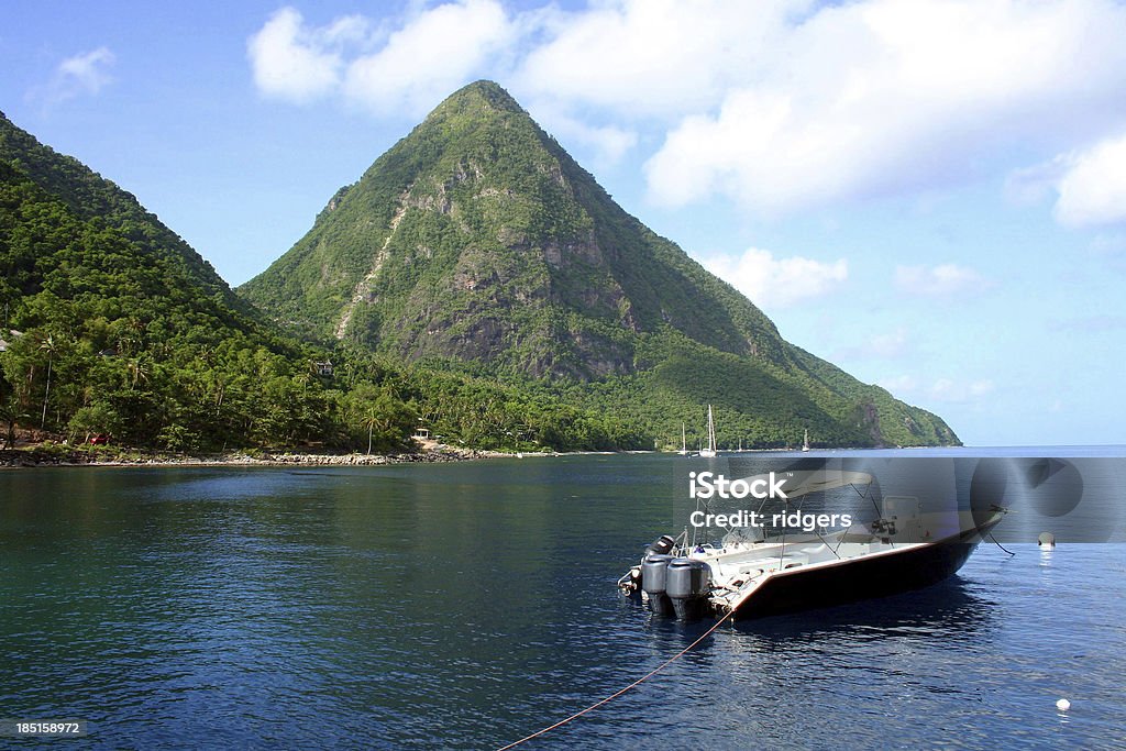 The Pitons in St Lucia A boat is moared in the harbour mouth of the Pitons in St Lucia. Caribbean Stock Photo