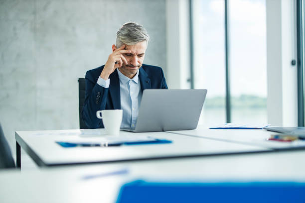 istock Mid adult businessman reading a problematic e-mail on laptop in the office. 1851615220