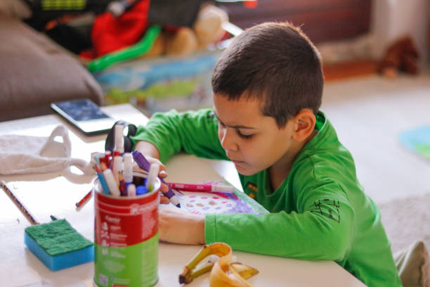 istock Boy draws with crayons on paper at home 1851622603