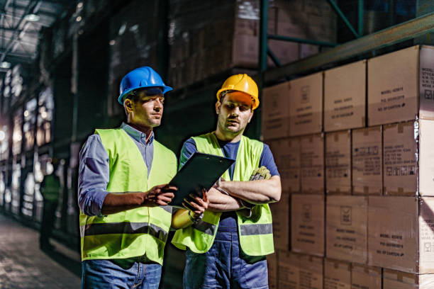 istock Warehouse worker and his manager going through checklist in a storage room. 1851628494