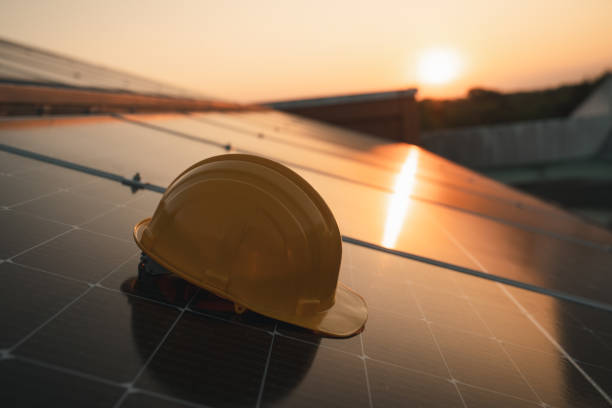 istock Yellow engineer hard safety helmet hat on solar cell panel. Clean energy concept. 1851667195