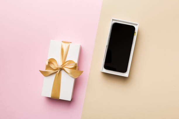 istock Opened gift box with gold ribbon and smartphone on color background, top view. Blank open box packaging mockup , Template for your design - branding mockup 1851674131