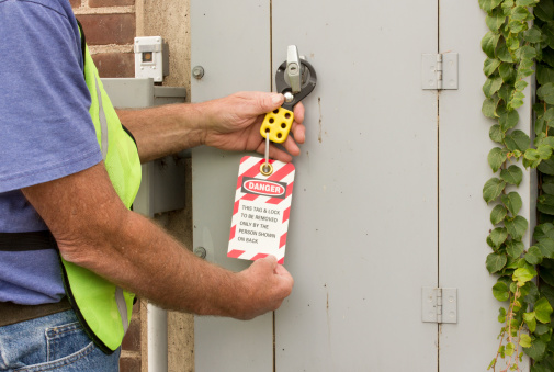 man attaching a lockout tag to an electrical control panel