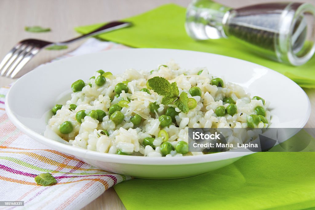 risotto italiano con riso, piselli, menta e formaggio - Foto stock royalty-free di Piselli freschi