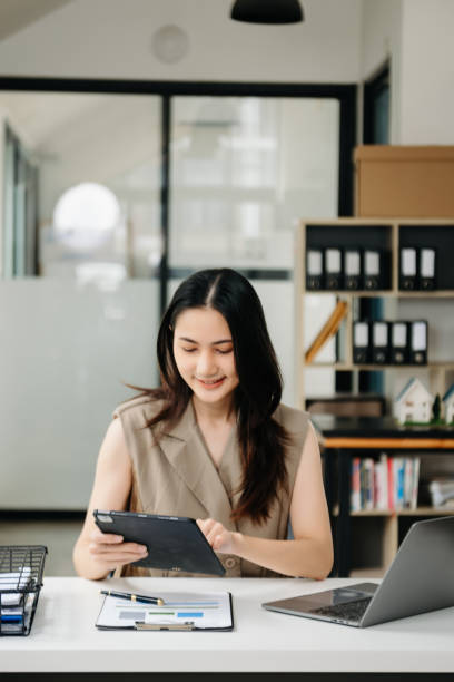 istock Young beautiful woman using laptop and tablet while sitting at her working place. Concentrated at work. 1851684786