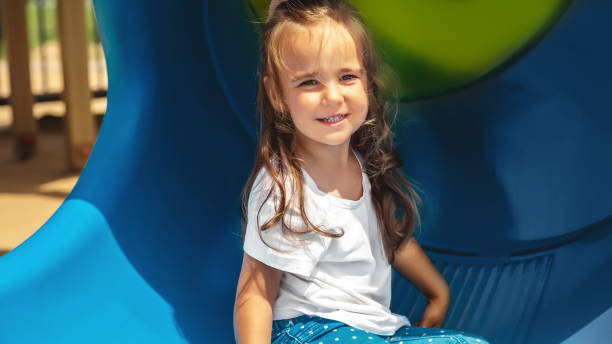istock active little girl on playground. playing child on slide 1851693783