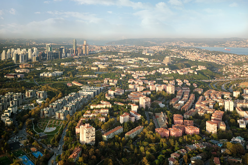Aerial view  to a modern city with skyscrapers, dormitory area and parks. Against the background of a sunset sky with clouds.