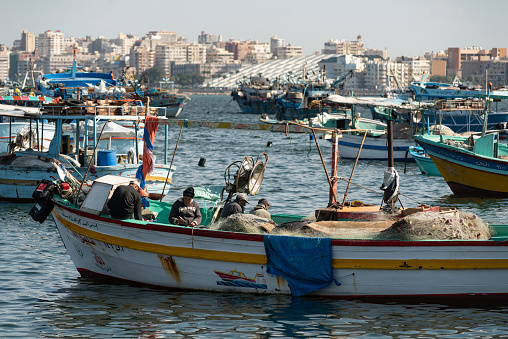 Alexandria, Egypt. December 3rd 2022\nLocal fishermen and fishing boats moored in the Mediterranean harbor of the Egyptian Delta port city of Alexandria, Egypt.