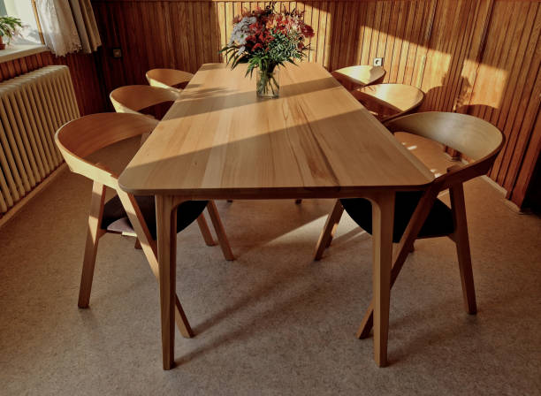 istock Armchair with a beech frame stained oak shade. Modern and desirable look with brown padding. a large table for the whole family gathering. light floor and wall paneling 1851754196