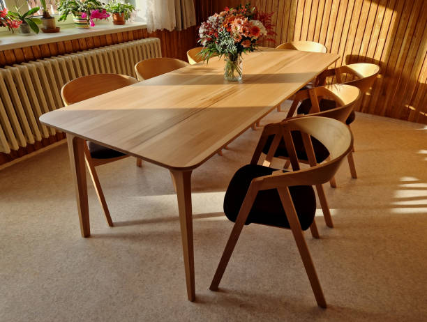 istock Armchair with a beech frame stained oak shade. Modern and desirable look with brown padding. a large table for the whole family gathering. light floor and wall paneling 1851755254