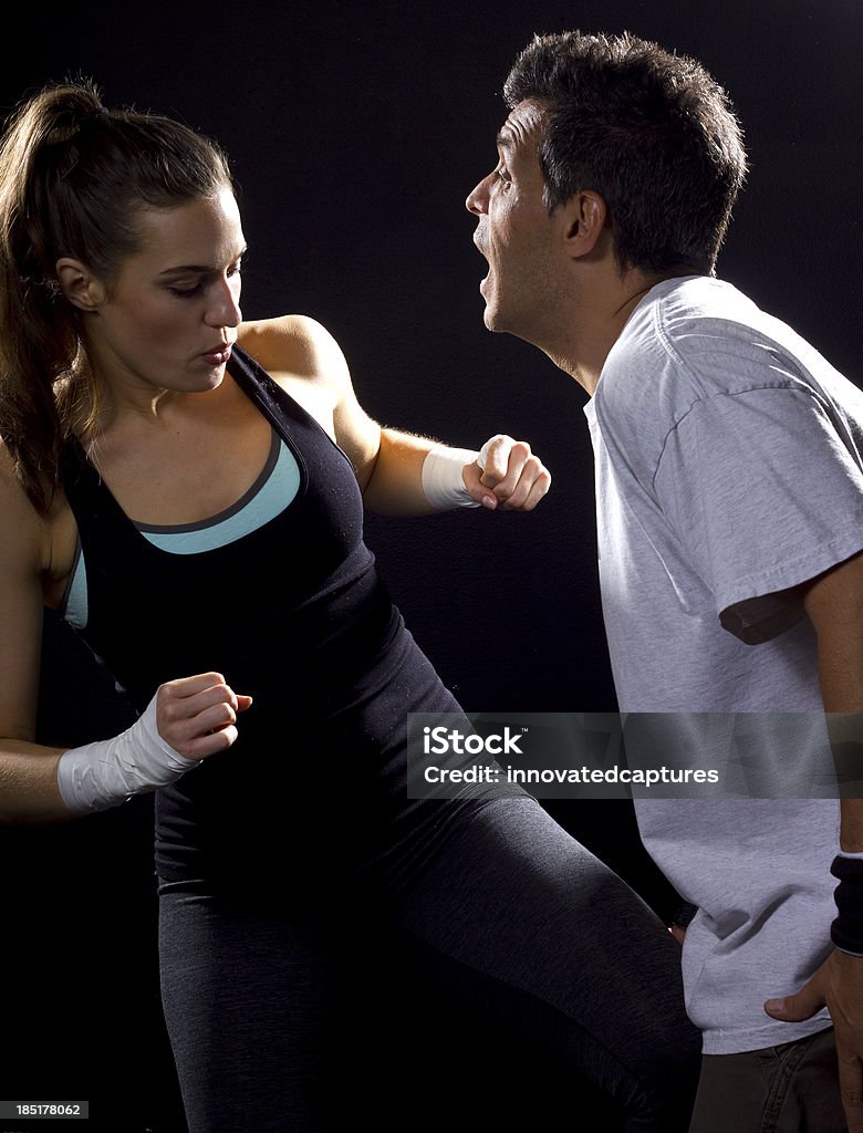 Ajuste jovens mulher lutando um homem em um fundo preto - Foto de stock de Academia de ginástica royalty-free