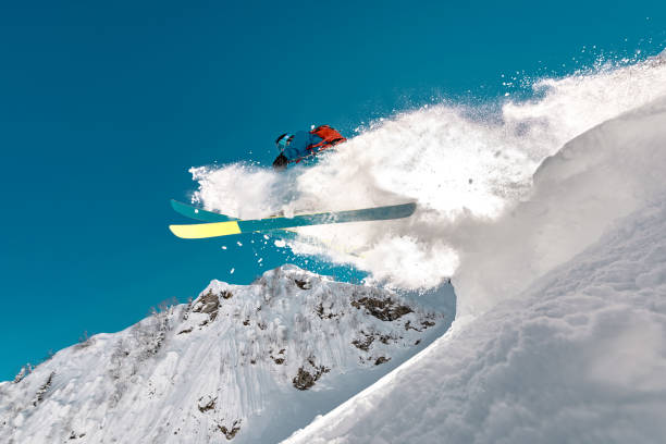 プロスキーヤーが山高くジャンプ - powder snow skiing agility jumping ストックフォトと画像