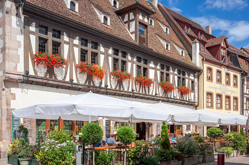 Obernai, France - August 11, 2022: Old town with restaurants and historic buildings, here pedestrian street Rue du Marche in Obernai. Bas-Rhin department in Alsace region of France