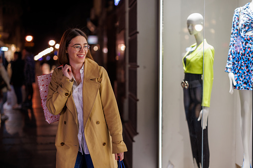 Succumb to the temptations of the night as a young woman engages in window shopping, irresistibly drawn by the allure of fashion