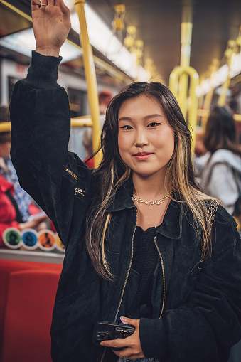 Young Asian woman riding subway train in Vienna.