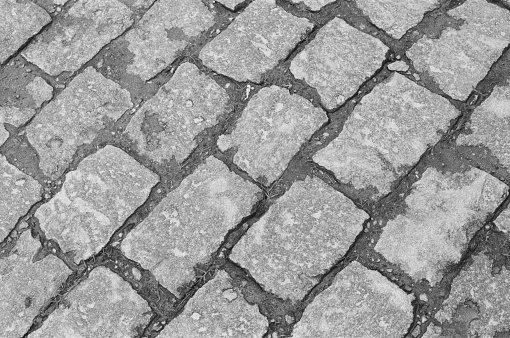 A close up of a street of bricks, made in film, black and white. Texture of bricks