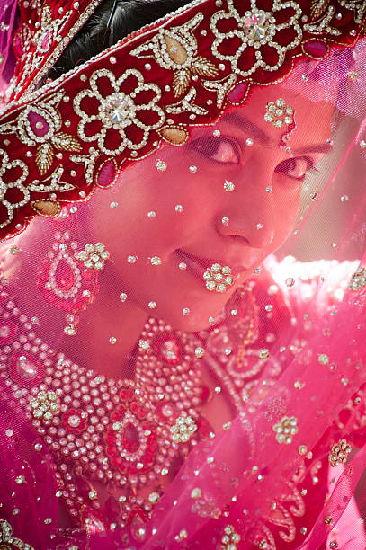 istock Young beautiful Indian bride looking through traditional veil 185184989