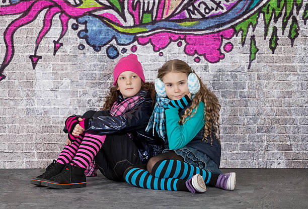 istock Two girls in front of the wall covered with graffiti 185185873